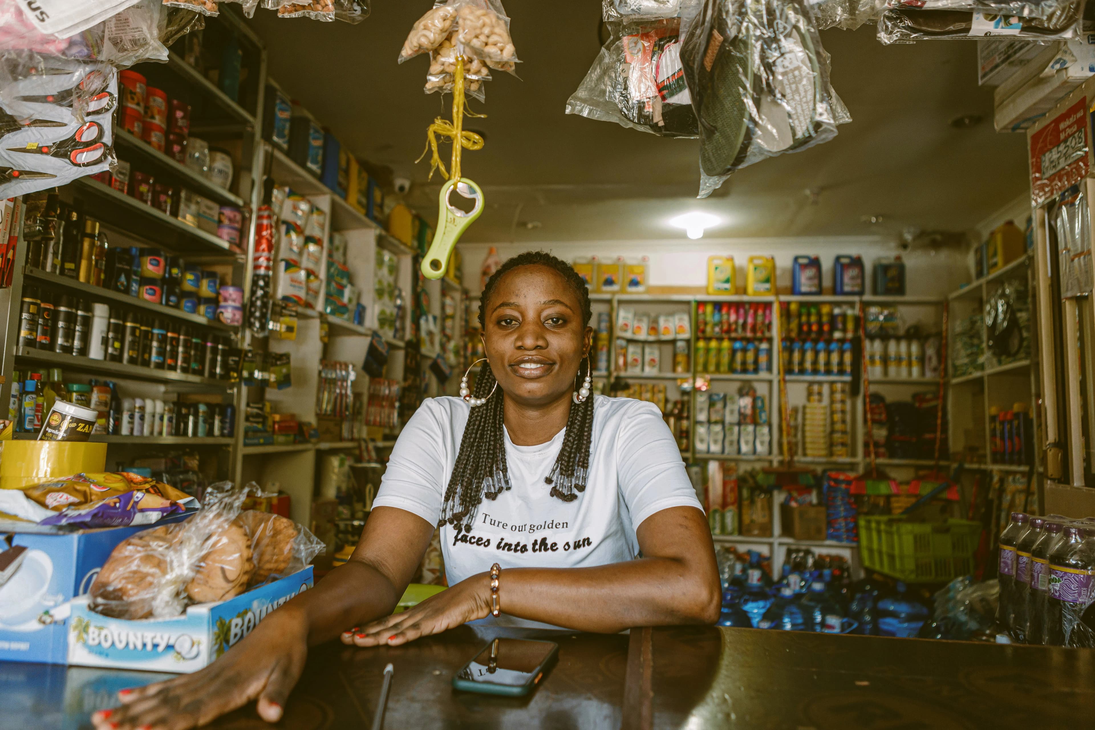 A shop owner smiling behind the counter of her provision store